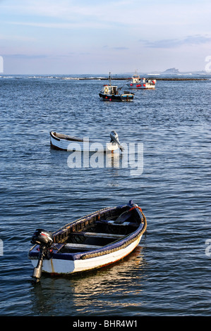 Boote ankern vor der Küste bei Lindisfarne. Bamburgh Castle ist nur sichtbar am Horizont. Stockfoto