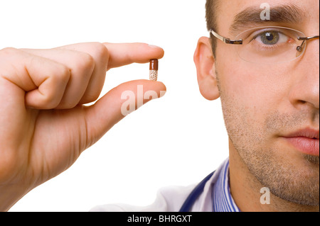 jungen männlichen Arzt hält Pille in Fingern Stockfoto