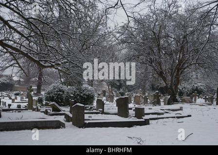St Leonards Friedhof mit Grabsteinen schneebedeckt, Heston West London, UK Stockfoto