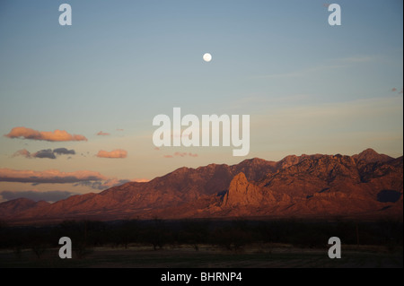 Santa Rita Mountains im Süden Arizonas in der Dämmerung mit dem Vollmond steigt über die Berge.  Die Farben rosa Sonnenuntergang Stockfoto