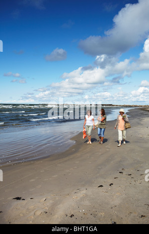 Lettland, Ost-Europa, Baltikum, westlichen Lettland, Liepaja, Frauen zu Fuß am Strand mit blaue Flagge Stockfoto