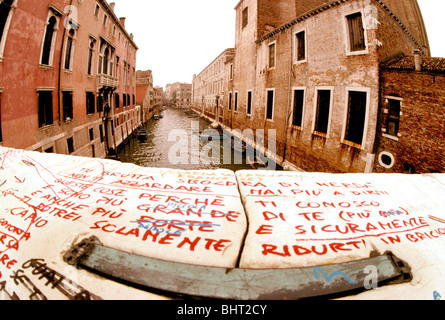 Weitwinkelaufnahme des alten venezianischen Gebäuden und Kanal, Graffiti auf steinerne Brücke im Vordergrund, Venedig, Italien Stockfoto