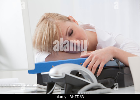 junge Frau schläft in ihrem Büro-Schreibtisch Stockfoto