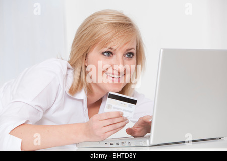 junge Frau mit Laptop und Kreditkarten-online-shopping Stockfoto