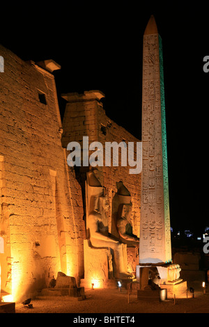 Beleuchtete Seitenansicht des ersten Pylon und rotem Granitobelisk von Luxor-Tempel in Luxor, Ägypten Stockfoto