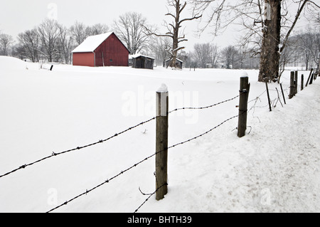 Rote Scheune und Zaun in den Schnee in Floyd County, Indiana Stockfoto