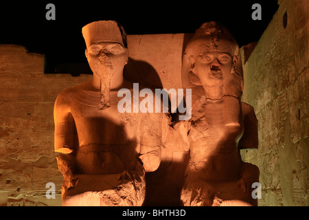 Beleuchtete Statuen von Tutanchamun und seine Frau Ankhesenamun auf der Kolonnade des Luxor-Tempels am Ostufer des Nils Stockfoto