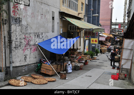 Baldachin beschattet Trockenfisch Lebensmittel Geschäfte unter Wohnungen in einer belebten Seitengasse in der Nähe des Voeux Road West, Hong Kong, China Stockfoto