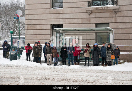 Menschen warten auf einen Bus in New York City während der Aufzeichnung Schneesturm am 26.02.2010 Stockfoto