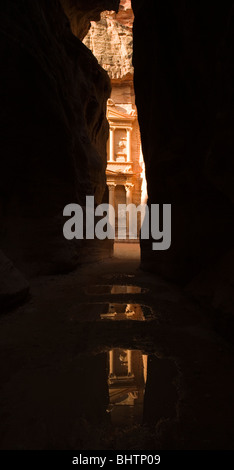 Die Schatzkammer oder Al Khaznah reflektierenden in Pfützen auf der antiken Stadt Petra gesehen Trog die Siq-Schlucht in Wadi Musa, Jordanien. Stockfoto