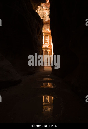 Die Schatzkammer oder Al Khaznah reflektierenden in Pfützen auf der antiken Stadt Petra gesehen Trog die Siq-Schlucht in Wadi Musa, Jordanien. Stockfoto