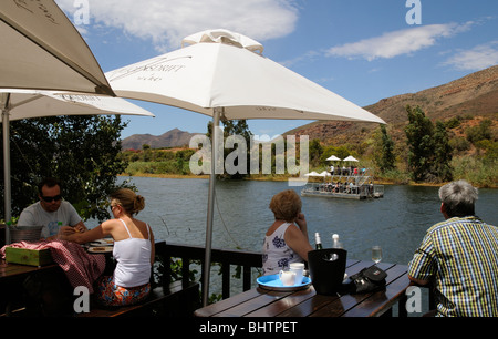 Gäste auf dem Viljoensdrift Weingut Mittagessen vom Ufer des Flusses und genießen eine Breede River Bootsfahrt vorbei an Stockfoto