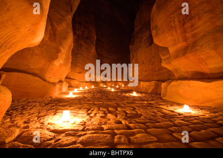 Die Al-Siq-Schlucht führt an den Fiskus beleuchtet mit Kerzen für Petra bei Nacht in Wadi Musa, Jordanien. Stockfoto