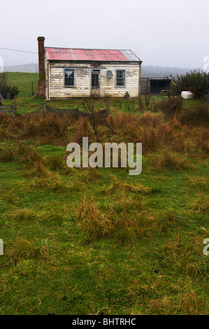 Eine heruntergekommene Häuschen auf isolierte Lande mit einem Ort Fernsehen Sat-Antenne an der Wand montiert. Stockfoto