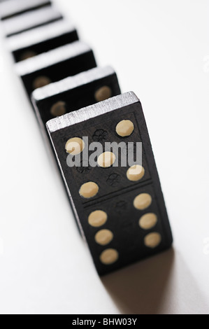 Dominosteine in einer Linie auf weißem Hintergrund von oben geschossen Stockfoto