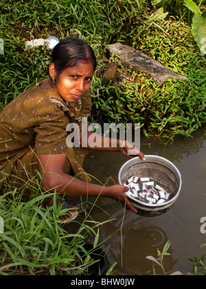 Indien, Kerala, Alappuzha, Chennamkary, Backwaters, Frau waschen zubereitet Fisch im Kanalwasser Stockfoto