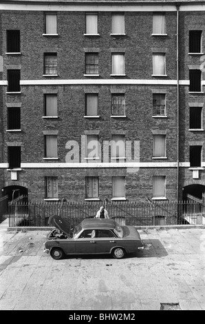 Mietshaus viktorianische Slums Peabody Housing Estate. Tower Hamlets Whitechapel East London UK 1970s Mann, der an seinem Auto vor seinem Wohnblock arbeitet. 1978 HOMER SYKES Stockfoto