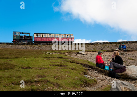 Menschen Essen neben dem Titel Zug in Snowdonia-Nationalpark, Gwynedd, Wales Stockfoto