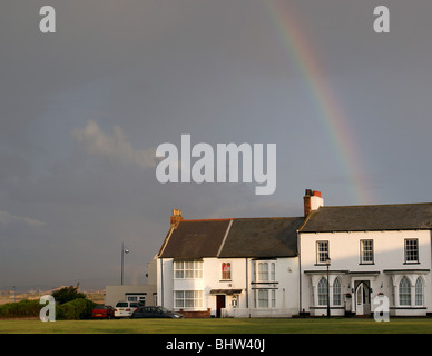 HÄUSER AUF DEM GRÜN BEI SEATON CAREW HARTLEPOOL UK MIT EINEM REGENBOGEN IN DEN HIMMEL NACH DEM STURM Stockfoto