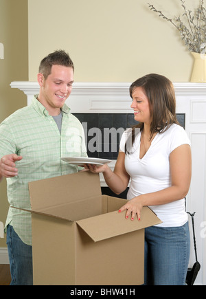 Attraktives junges Paar Auspacken Gerichte In ihrer neuen Heimat Stockfoto