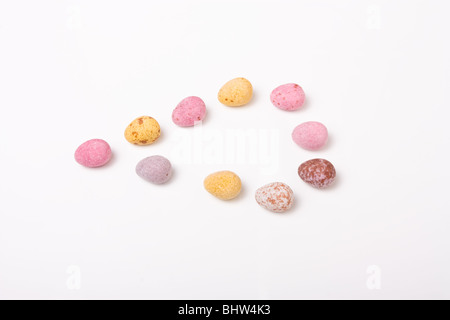 Candy bedeckt kleine Schokoladeneier aus niedrigen Sicht vor weißem Hintergrund. Stockfoto