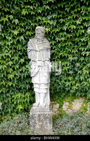 Eine klassische Statue mit einer Efeu-Hecke im Hintergrund Stockfoto