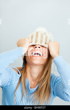 Porträt der jungen Frau lachen während für Gesicht mit Wollmütze. Vertikale Form, Textfreiraum Stockfoto