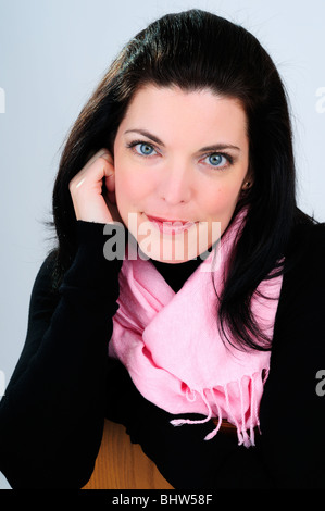 Schöne Brünette junge Frau trägt einen rosa Schal Stockfoto