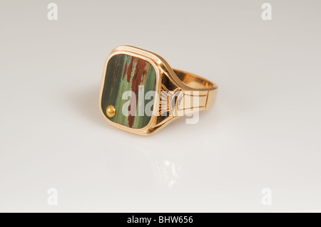 Dieses Mannes Goldring hat eine Bild-Achat in grün und braun Tönen mit einem goldenen Punkt auf der Seite isoliert auf einem hellen Hintergrund. Stockfoto