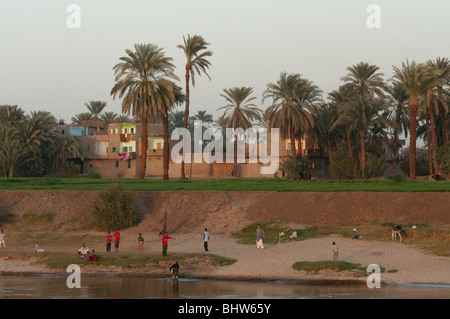 Kinder spielen am Ufer des Nils, in der Nähe von Luxor, Ägypten mit der lokalen Bevölkerung in bunten Kleidern Stockfoto