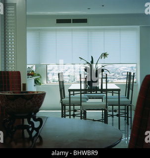 Stühle und Tisch vor große Fenster mit weißen blind in modernen weißen Speisesaal in Stadtwohnung Stockfoto