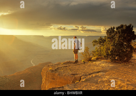 Wanderer steht auf Rim des Grand Canyons in der Nähe von Hopi Point bei Sommer Sonnenuntergang, Grand Canyon National Park, Arizona, USA Stockfoto