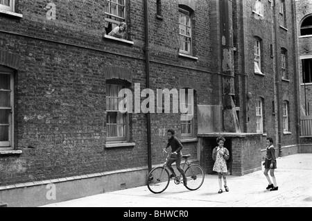 Viktorianisches Slum Building Peabody Housing Estate. Tower Hamlets Whitechapel East London UK 1970s Multirassisches Großbritannien, eingewanderte Kinder spielen im Gemeindebereich des Wohnblocks. 1975 HOMER SYKES Stockfoto