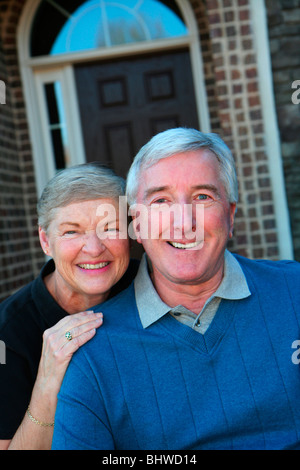 Glücklich Senior paar lächelnd draußen vor dem Haus Stockfoto