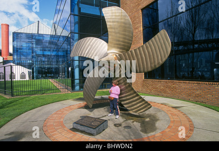 Ein junger Besucher unter einer riesigen Schiffsschraube bei OMSI, Oregon Museum of Science and Industry in Portland, Oregon Stockfoto