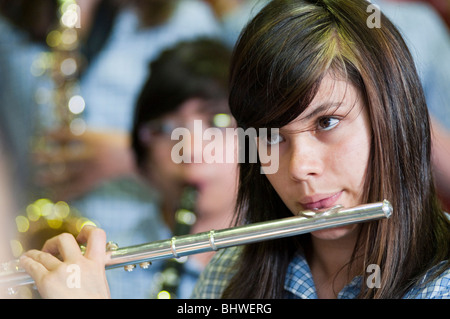 Ein junges Mädchen, das Flötenspiel in einem High-School-Orchester Stockfoto