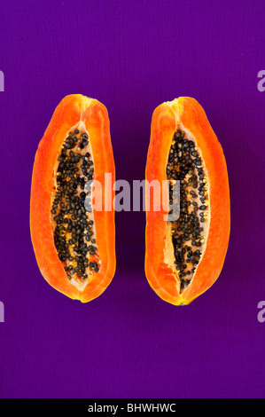 Papaya mit Samen lila Hintergrund schneiden Stockfoto