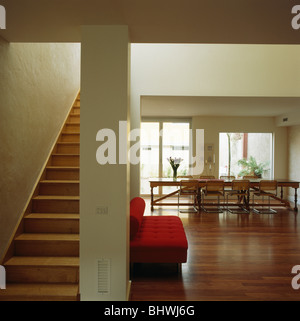 Holztreppe und Bodenbelag in große offene moderne weiße Saal Speisesaal mit roten sofa Stockfoto