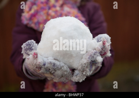 Kind hält einen Schneeball Stockfoto