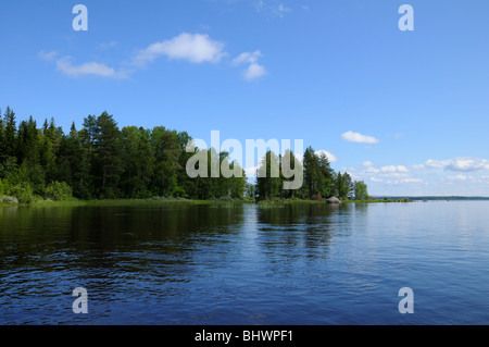 Das schöne Bild der karelischen Wald am Rande eines Sees und einigen riesigen Felsblock in diesem See Stockfoto