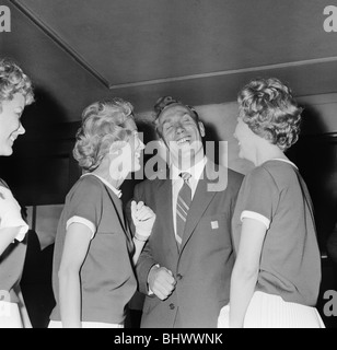 England Fußballer Billy Wright wird von seiner Freundin Joy Beverley Sisters begrüßt, als er am Londoner Flughafen, kommt nach Englands Beseitigung von der Weltmeisterschaft 1958 in Schweden. Hier ist er mit anderen die beiden Zwillingsschwestern Teddie und Babs zusammen. 23. Juni 1958. Stockfoto