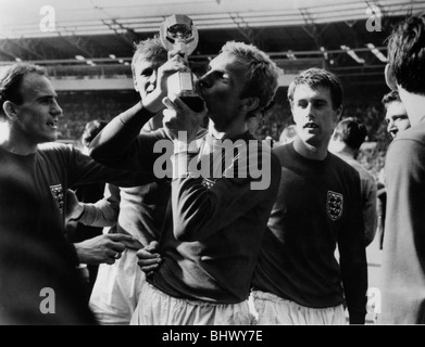 Fußball World Cup-Finale 1966 England 4 Westdeutschland 2 Wembley. England-Kapitän Bobby Moore küsst Tasse beobachtet von Geoff Hurst Stockfoto