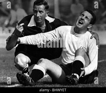 Dave Mackay Spurs Fußballspieler September 1964 liegen auf Boden mit gebrochenem Bein während Reserve Spiel gegen Shrewsbury haben gerade zurückgekommen aus früheren gebrochenen Bein durch Schiedsrichter Peter Songhurst Tottenham Hotspur unterstützt Stockfoto