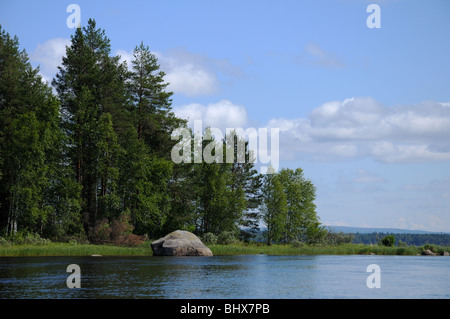 Das schöne Bild der karelischen Wald am Rande eines Sees und einigen riesigen Felsblock in diesem See Stockfoto