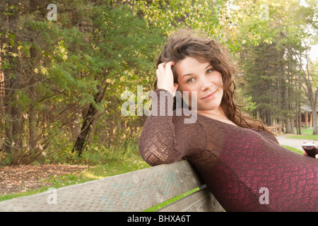 Schwangere Frau sitzend auf einem Park Bench, Manitoba, Kanada Stockfoto