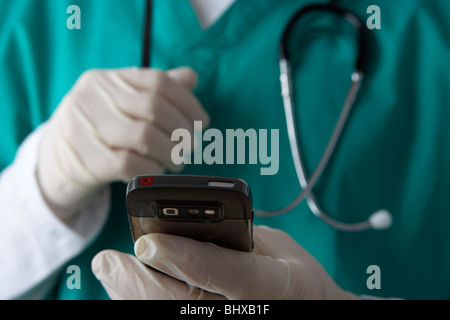 Mann trägt medizinische Peelings und Stethoskop hält Handy Nachrichten Stockfoto