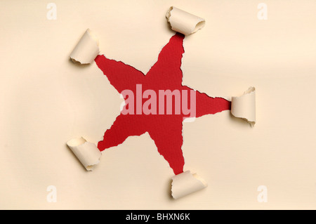 Leichtes gelbes Papier bilden star mit rotem Papierhintergrund gerissen Stockfoto
