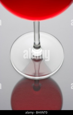 Rotwein in einem Glas auf grauen und schwarzen Hintergrund mit Reflexion Stockfoto
