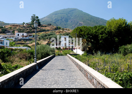 Ein Fußgängerweg im Dorf Lingua und der ruhende Vulkan des Monte Fossa delle Felci auf der äolischen Insel Salina, Sizilien, Italien. Stockfoto