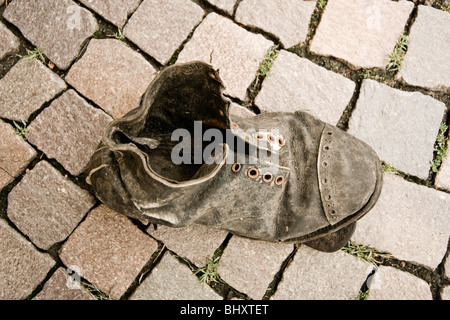 Alte Leder-Schuh auf einer Straße Stockfoto